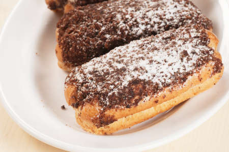 Eclairs with chocolate chips on a plateの写真素材