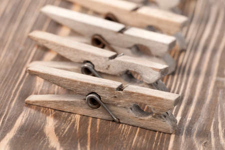 Old wooden clothes pins  on a timber board, close-upの写真素材