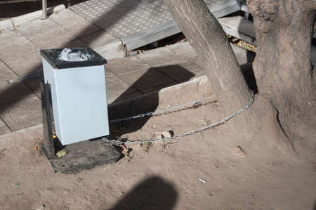Litter basket fixed with chain to a tree