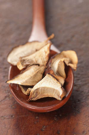 Boletus edulis dry mushrooms on a timber boardの写真素材