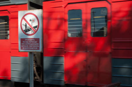 Prohibitive tablet and the passing train on the railway. Writing on a tablet walking across the...