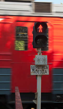 Prohibitive tablet, traffic lights and the passing train on the railway. Writing on a tablet "mind the train!"の写真素材