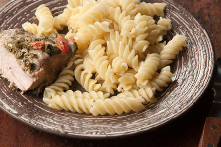 Turkey breast baked with pasta fusilli on a plateの写真素材