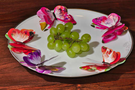 Grape and butterly on the white plateのeditorial素材