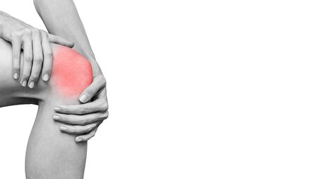 Knee inflammation. Young woman massaging her painful knee.の写真素材