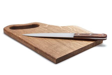 A large stainless steel cook knife with a wooden handle lies on a handmade cutting board made of...