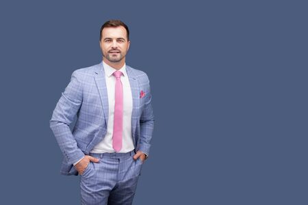 Man in elegant suit posing in blue background.の写真素材