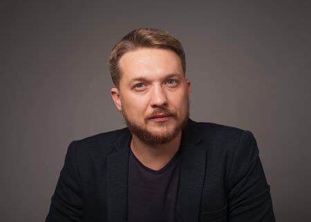 Handsome man over dark background looking at camera.の写真素材