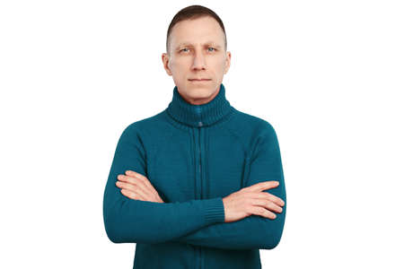 Serious average age man with crossed arms in blue sweater isolated on white background.の写真素材