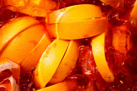 Lemonade with oranges and ice cubes top view close-up.