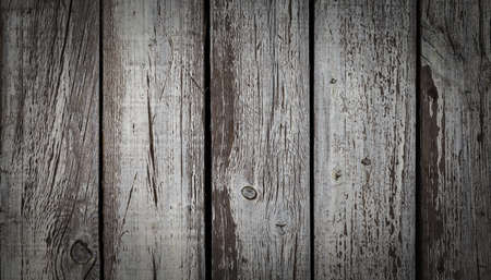 Old wooden wall with weathered and peeled white paint.の写真素材