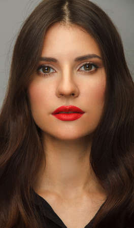 Vertical portrait of young woman with red lips and long hair.の写真素材