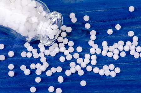 homeopathic globules on a blue wooden backgroundの写真素材