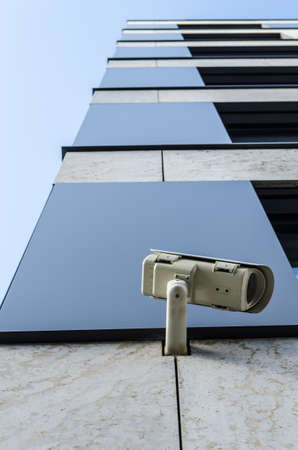 surveillance monitoring security camera on a house corner with blue skyの写真素材