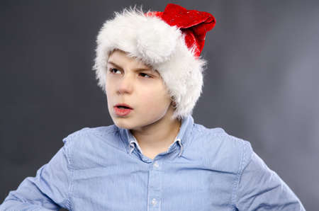 angry young boy with a santa hat の写真素材