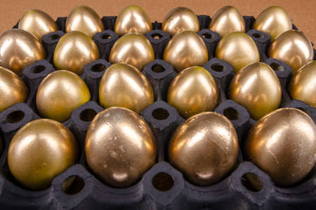 black egg package with golden easter eggsの写真素材