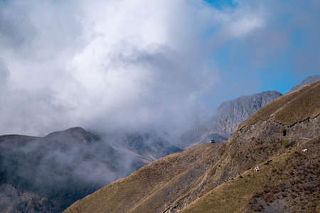Caucasus, Georgia, Tusheti region, Omalo. An off-road car is park in front of a landscape view of caucasus mountains in Georgiaの写真素材