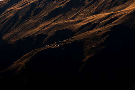 Caucasus, Georgia, Tusheti region, Omalo. A village on a mountainside is lit by the setting sun in the Tusheti region.の写真素材