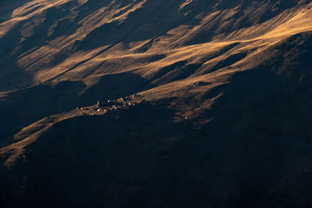 Caucasus, Georgia, Tusheti region, Omalo. A village on a mountainside is lit by the setting sun in the Tusheti region.の写真素材