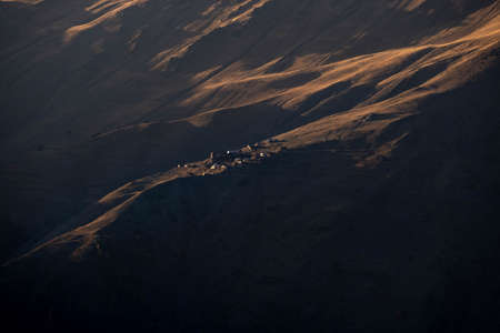 Caucasus, Georgia, Tusheti region, Omalo. A village on a mountainside is lit by the setting sun in the Tusheti region.の写真素材