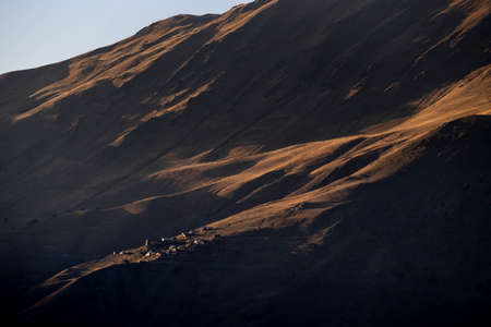 Caucasus, Georgia, Tusheti region, Omalo. A village on a mountainside is lit by the setting sun in the Tusheti region.の写真素材