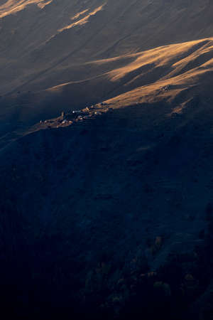 Caucasus, Georgia, Tusheti region, Omalo. A village on a mountainside is lit by the setting sun in the Tusheti region.の写真素材