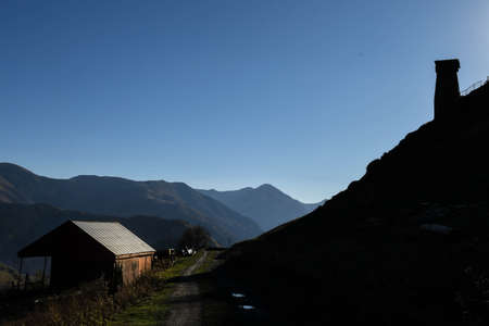 Caucasus, Georgia, Tusheti region, Omalo. A pathway crosses a house on the left and an ancient tower on the right in Omala - Tushetiのeditorial素材