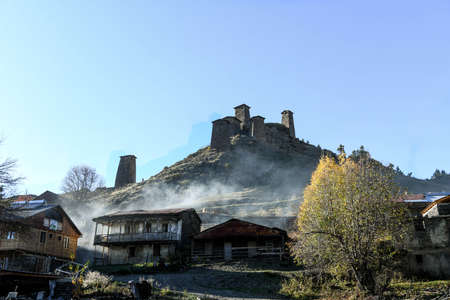 Caucasus, Georgia, Tusheti region, Omalo. The old fort overlooks the village of upper Omalo drowned in the smoke of a chimneyのeditorial素材