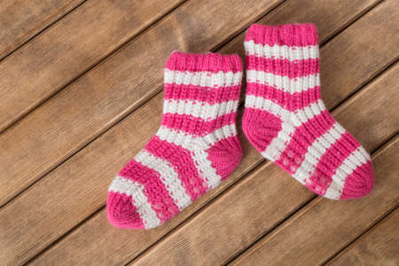 Funny baby socks on the background of wooden table  の写真素材