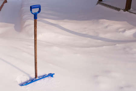 Snow cleaning shovel near the house .の写真素材