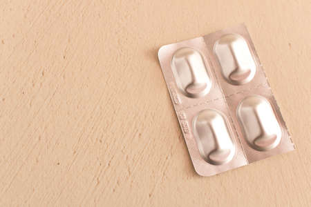 The packaging of pills on the table . On a beige backgroundの写真素材