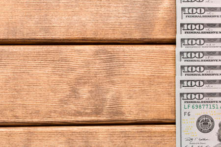 Hundred dollar bill with a smartphone on the tableの写真素材