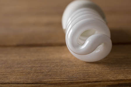 Energy-saving light bulb lies on a wooden table .の写真素材