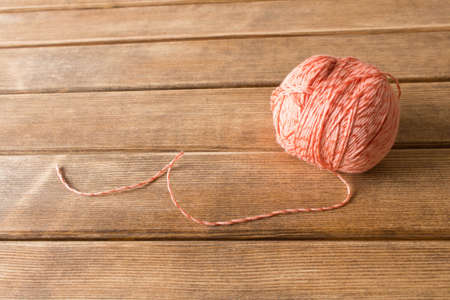 A ball of thread on the table . On the background of wooden table .の写真素材