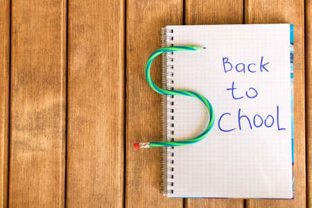 Inscription back to school in Notepad on wooden background .の写真素材