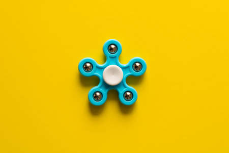 Blue spinner . Isolated on yellow background .