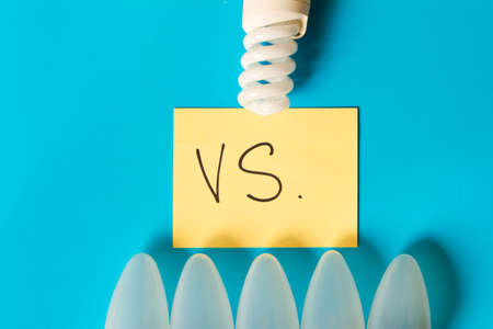 Energy-saving Lamp vs. incandescent lamp . The concept of energy saving . Isolated on turquoise...