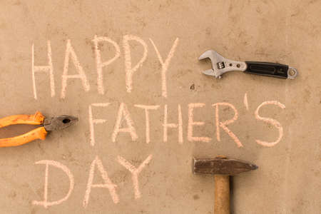 Happy father's day . Various tools on the cement floor .