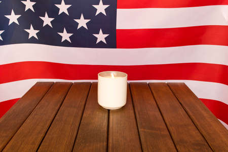 American flag and memorial candle on veterans day . On wooden backgroundの写真素材