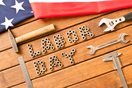 Labor day. American flag.  Different tools on wooden background .