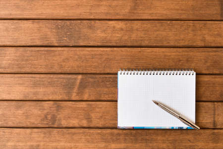 Clean sheet of notebook with pen on wooden office Desk . With empty space for text.の写真素材
