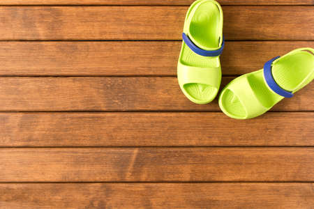 Baby flip flops on wooden background. Children's shoes.  the Concept of summer. Empty text space.の写真素材