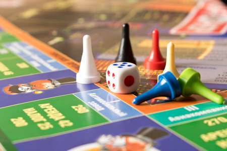 Multi-colored game chips with dice on the playing board. Board game.の写真素材