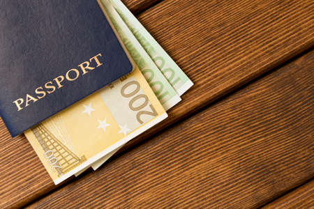 Passports with Euro banknotes on a wooden table . Travel readiness concept. Empty text space.