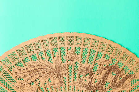 Beautiful wooden fan on the turquoise background.の写真素材