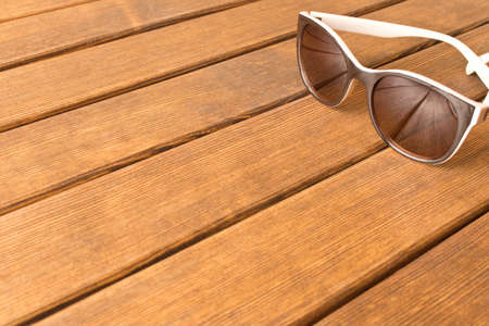 Sunglasses on a wooden table. The concept of summer. Empty text space.の写真素材