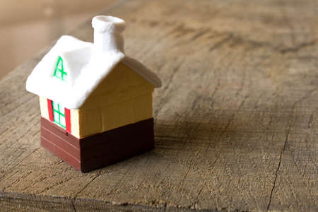 Small toy house on an old wooden table.