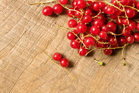 Fresh red currant on a wooden table. The concept of natural food.の写真素材