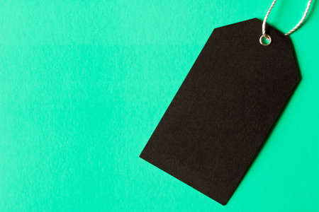 Black empty label . Isolated on turquoise background.の写真素材