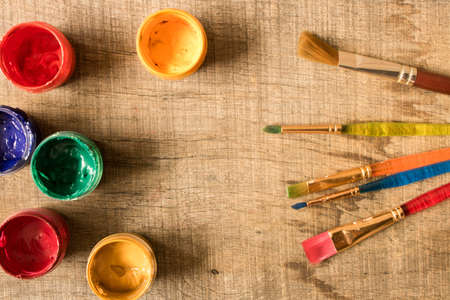 Various brushes and paints on the old wooden table . The view from the top. Creative concept.の写真素材
